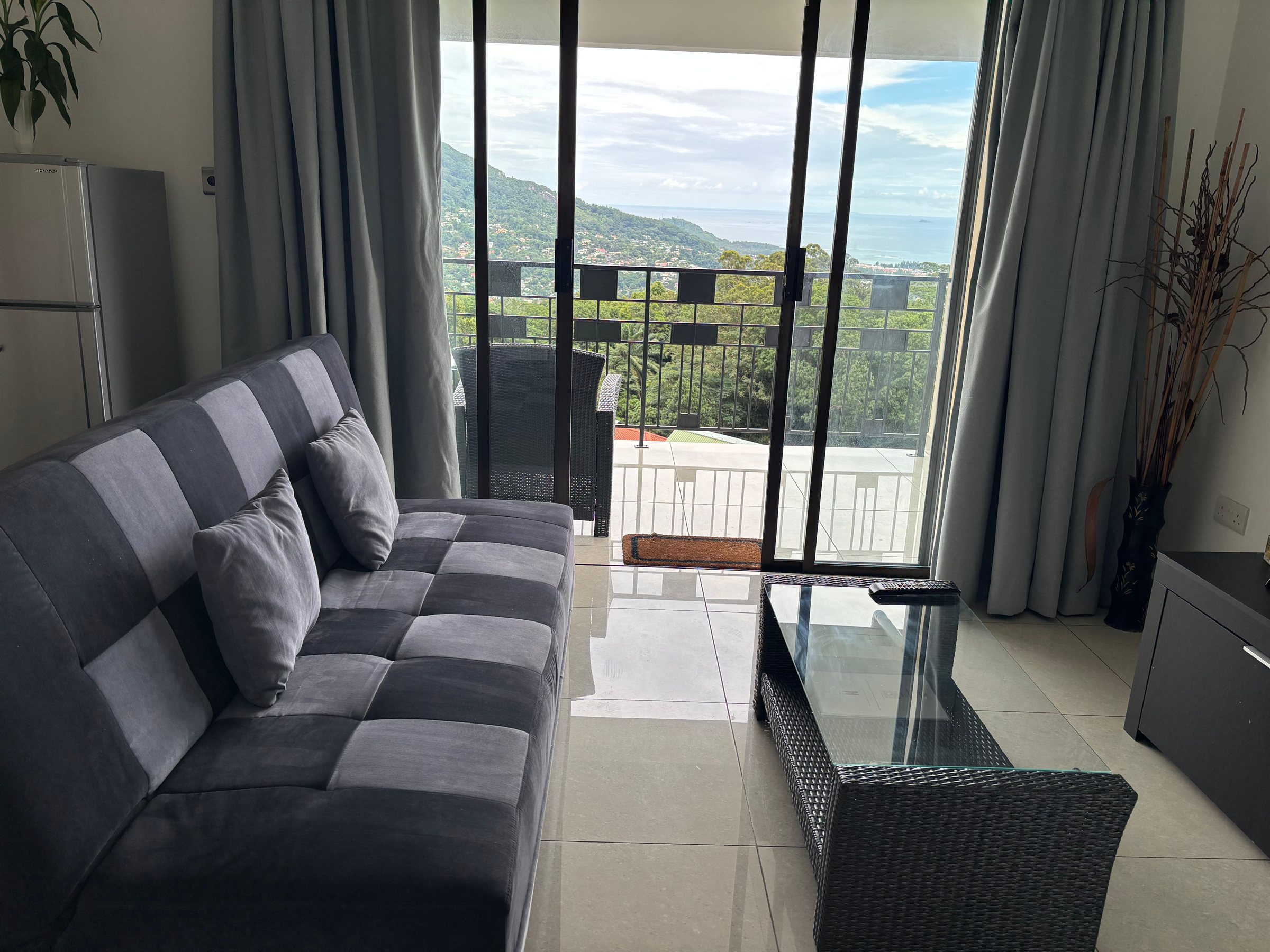 Sofa with mountain and ocean view through sliding doors